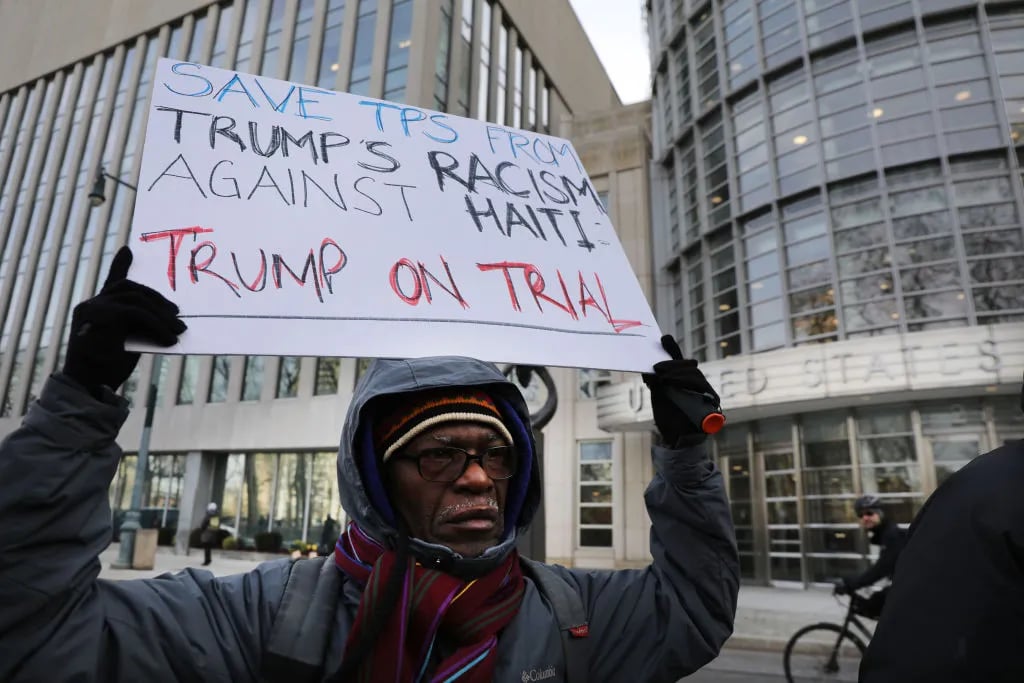 NEW YORK, NEW YORK - JANUARY 07: People demonstrate as a trial begins to try to protect Haitians immigrants under the Temporary Protected Status (TPS) from being deported back to Haiti in front of the Eastern District of New York Federal Courthouse in downtown Brooklyn on January 07, 2019 in New York City. President Donald Trump is trying to end TPS for Haitians which was granted to them following the 2010 7.0 magnitude earthquake which decimated the island nation and resulted in the death of 250,000 Haitians. TPS allows immigrants to work and live in the United States following a natural disaster or an ongoing armed conflict in their home country. (Photo by Spencer Platt/Getty Images)