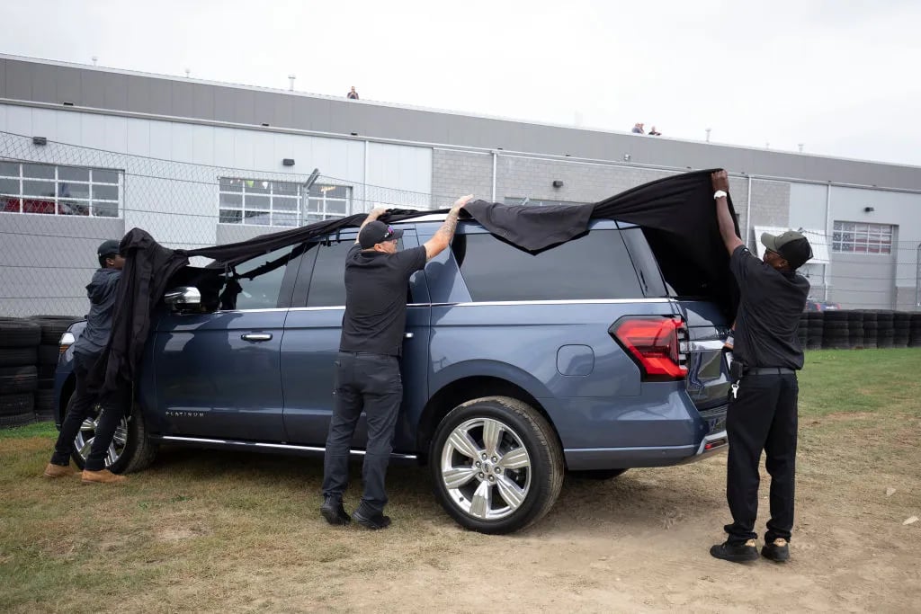 PONTIAC, MI - SEPTEMBER 21: A crew removes a cover off the new 2022 Ford Expedition full size SUV to display it after it was revealed to the news media during its debut at the 2021 Motor Bella auto show on September 21, 2021 in Pontiac, Michigan. The outdoor show runs from September 21 to September 26 and features over 350 cars, trucks, and utility vehicles on display, ride-along opportunities with professional drivers on a hot laps track, test drives, off-road track activations, and unique technology displays.