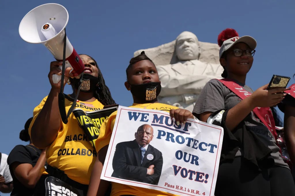 Shenita Binns (L) and her daughter Ysrael Binns (2nd L) of Atlanta, Georgia, participate in a “Freedom Friday March” protest at Martin Luther King, Jr. Memorial August 6, 2021 in Washington, DC. Activists continued to demonstrate for voting rights on the 56th anniversary of the signing of the Voting Rights Act and urged the US Senate “to end the filibuster so we can pass legislation to solve the urgent crises confronting our nation, voting rights, DC statehood, and reparations.”