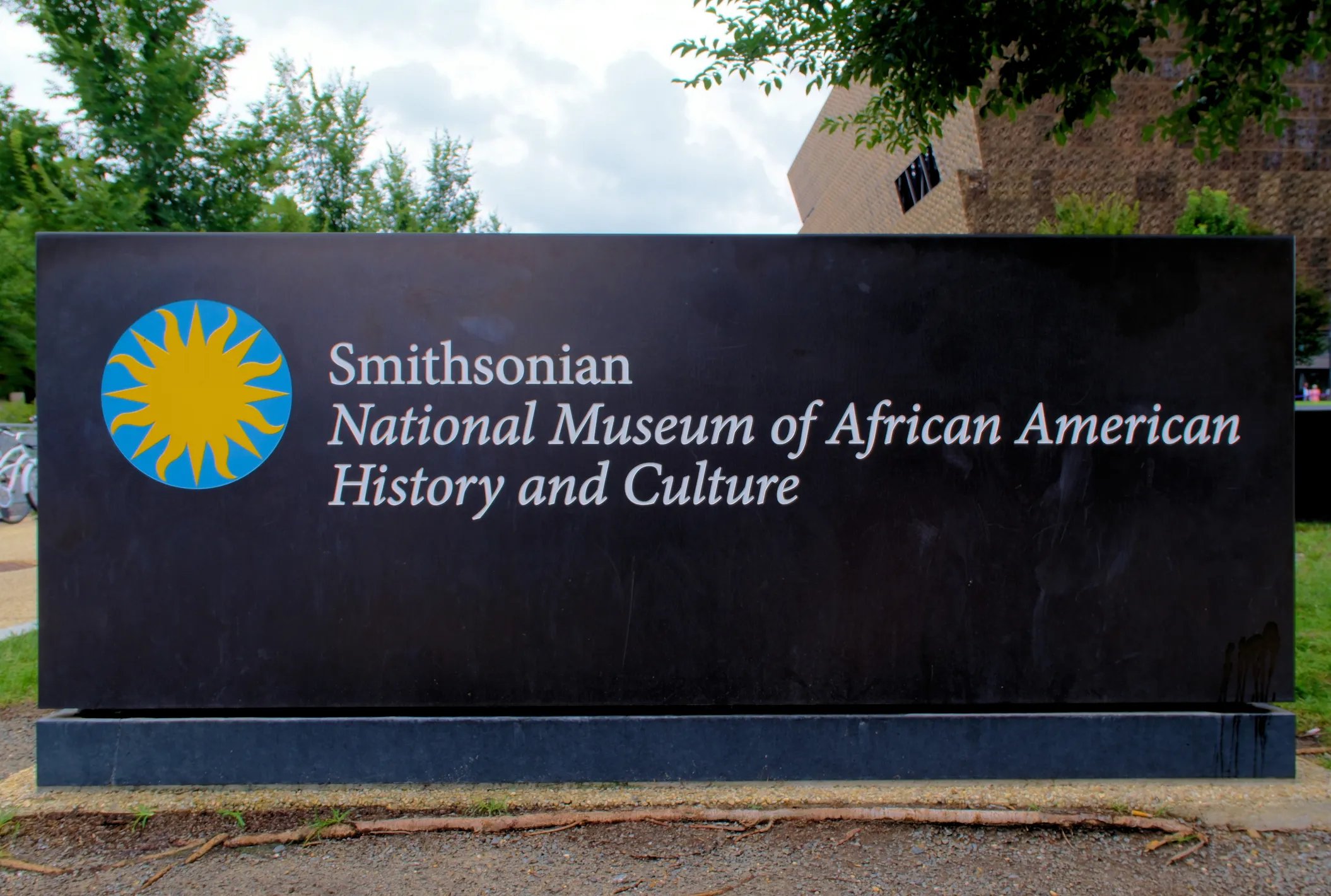 Washington, DC USA August 4, 2024: Sign for the Smithsonian Museum of African American History and Culture in the foreground with a partial view of the building in the background.