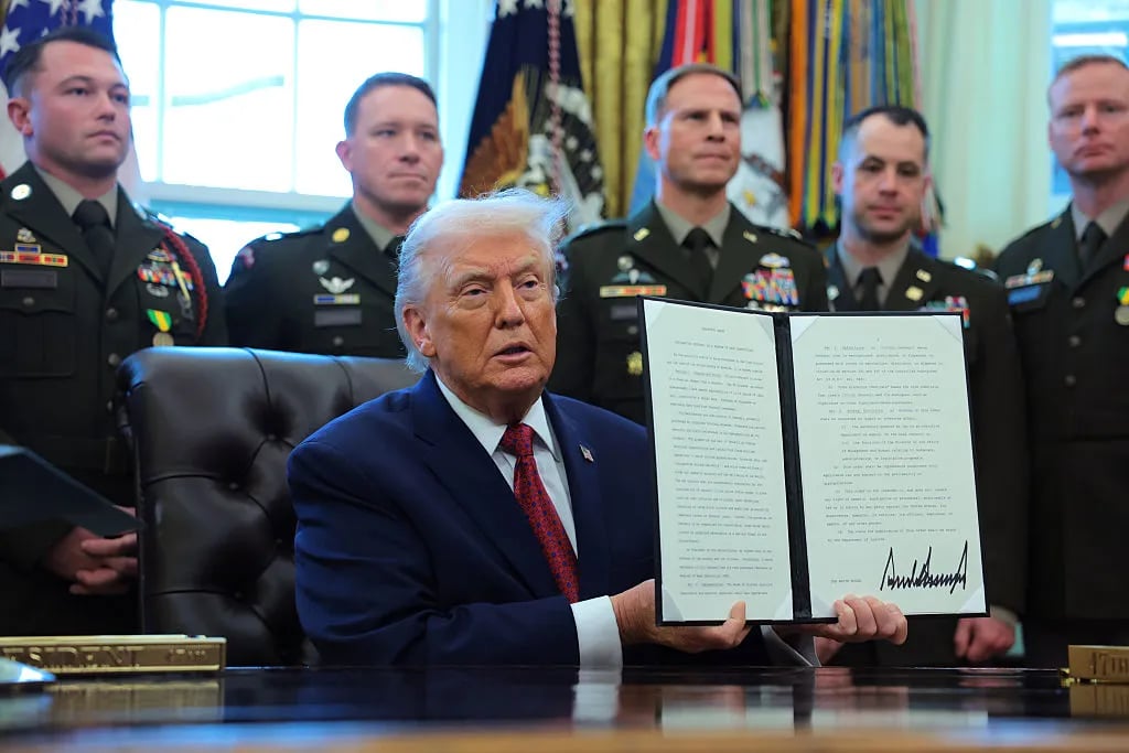 WASHINGTON, DC - DECEMBER 15: U.S. President Donald Trump poses with a recently signed executive order classifying fentanyl as a "weapon of mass destruction," during a ceremony for the presentation of the Mexican Border Defense Medal in the Oval Office of the White House on December 15, 2025 in Washington, DC. During the ceremony, Trump recognized the first 13 service members to receive the recently established Mexican Border Defense Medal (MBDM), which recognizes service members supporting Customs and Border Protection on the U.S.-Mexico border.