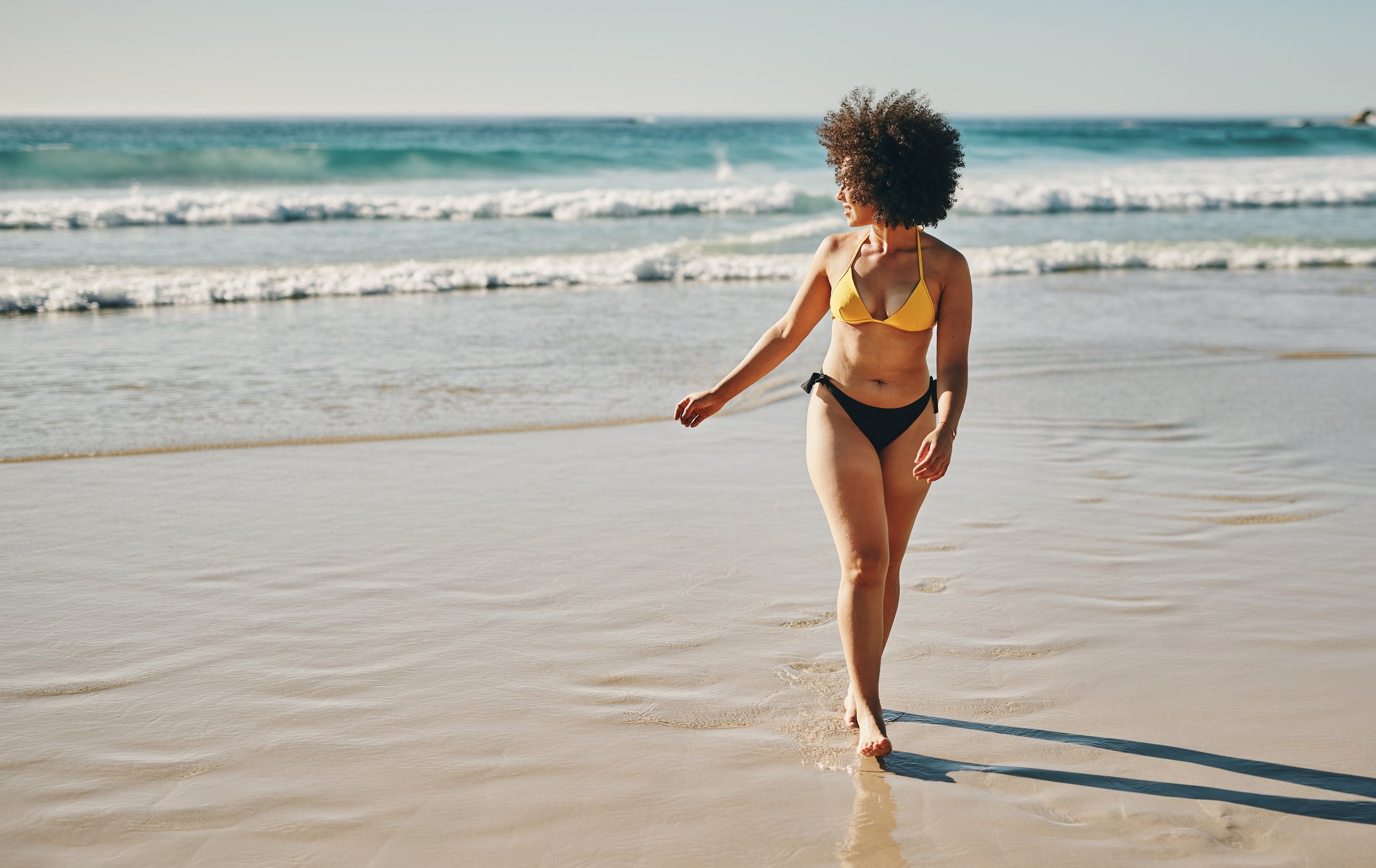 Full length shot of an attractive young woman enjoying a day out on the beach alone