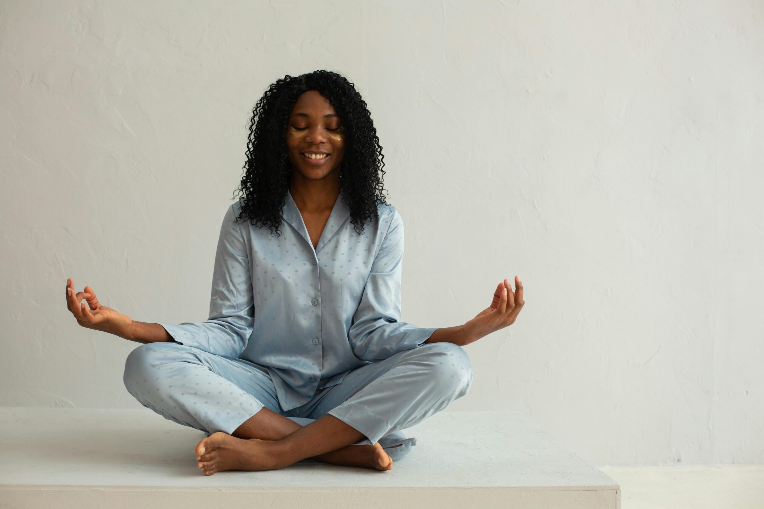 A Black woman doing the lotus yoga pose. what-is-the-lotus-pose-in-yoga