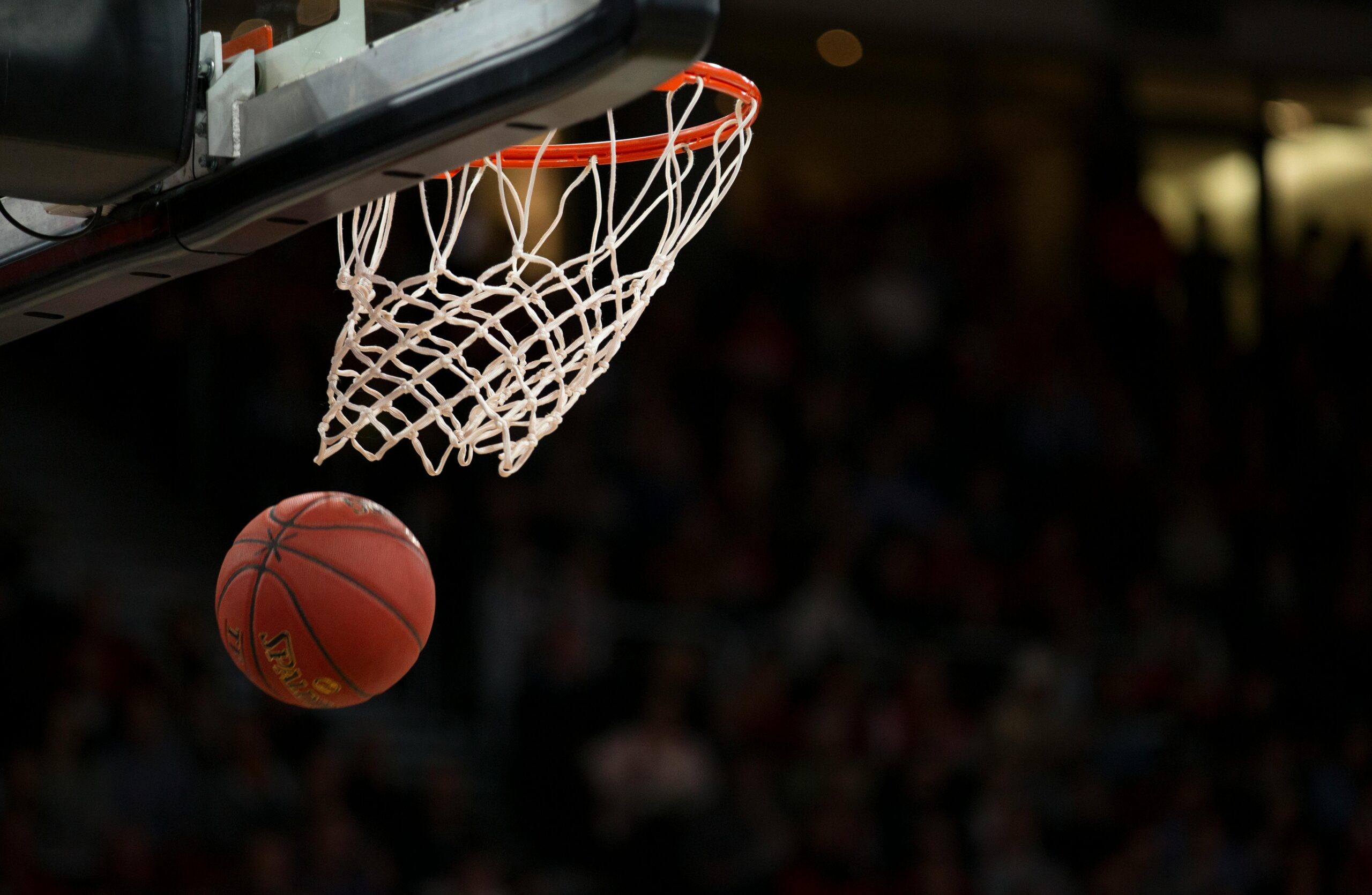 A basketball going through the basketball net at a game. ncaa-women's-basketball-rankings
