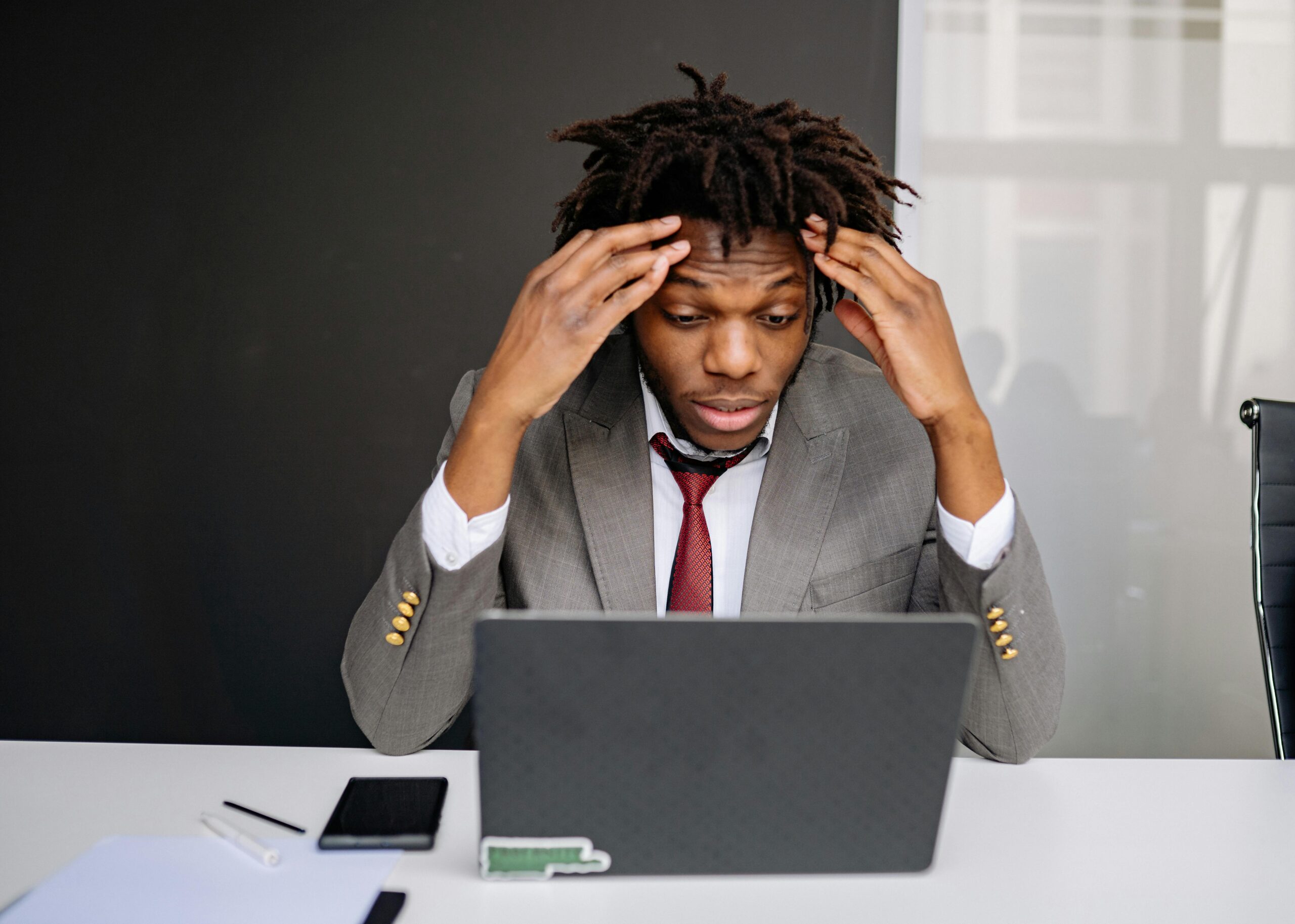 A Frustrated Black Businessman in Front of a Laptop, deciding if he needs a stress test