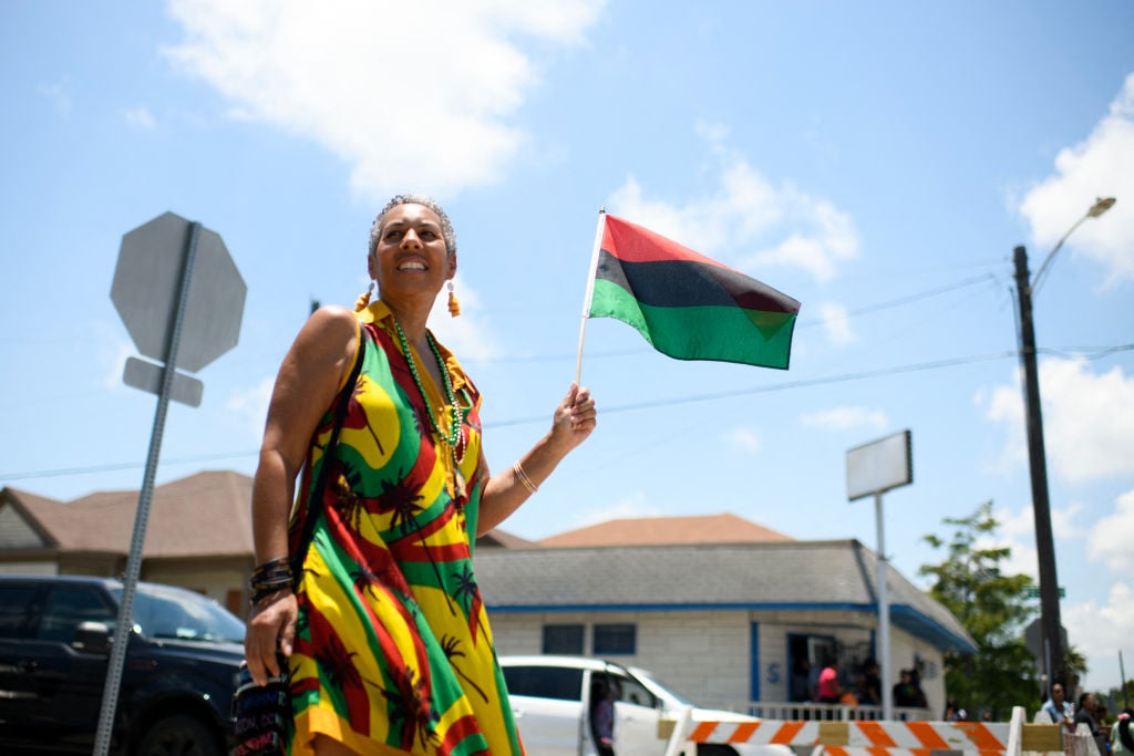A woman waves a flag during the 45th annual Juneteenth National Independence Day celebrations in Galveston, Texas, on June 15, 2024. Juneteenth falls on June 19 and has often been celebrated on the third Saturday in June, to mark the end of slavery in the US. 