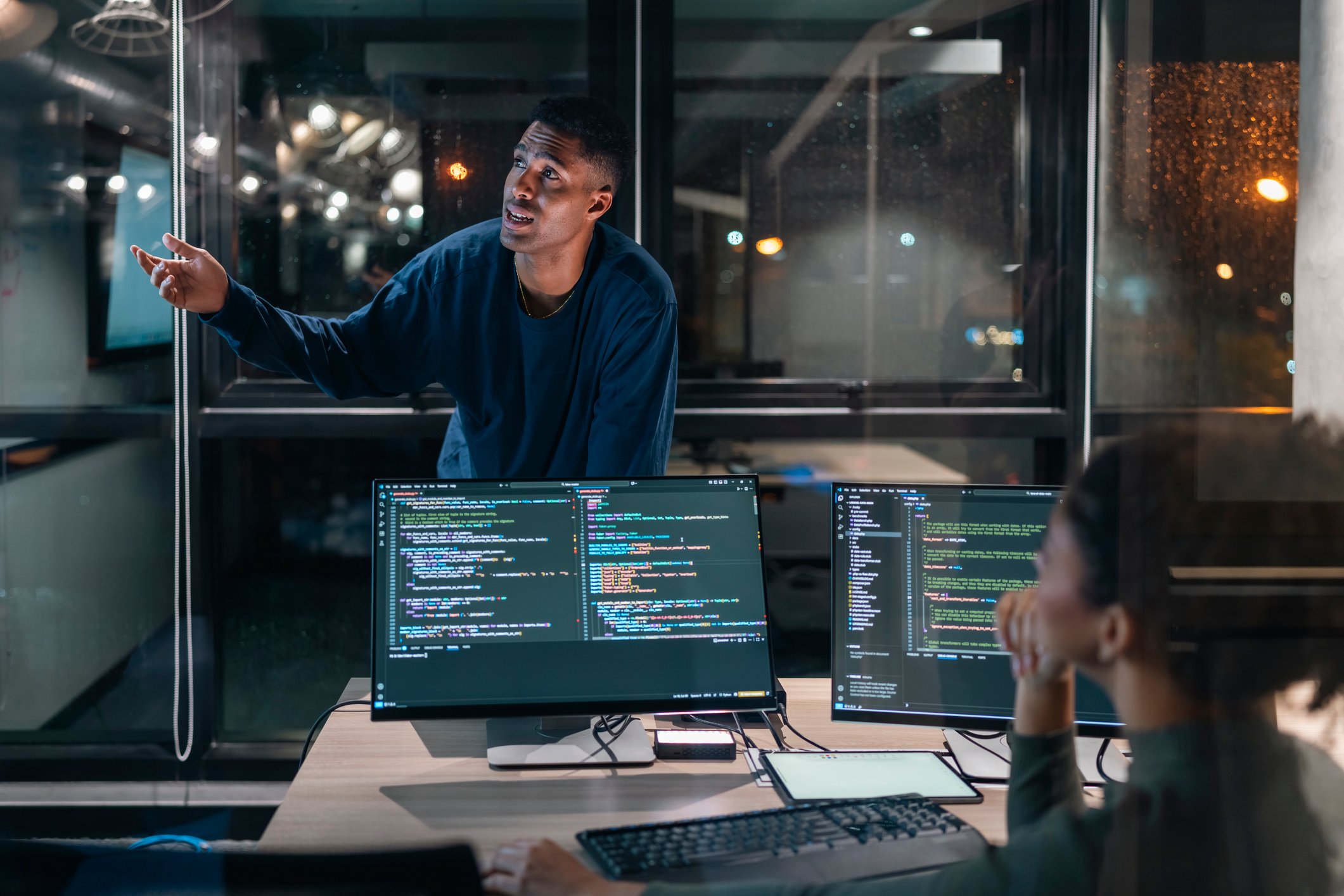 Two computer programmers working together on a computer code at night, Computer operators running system diagnostic tests. IT specialists deploying error checking utilities to fix network issues.