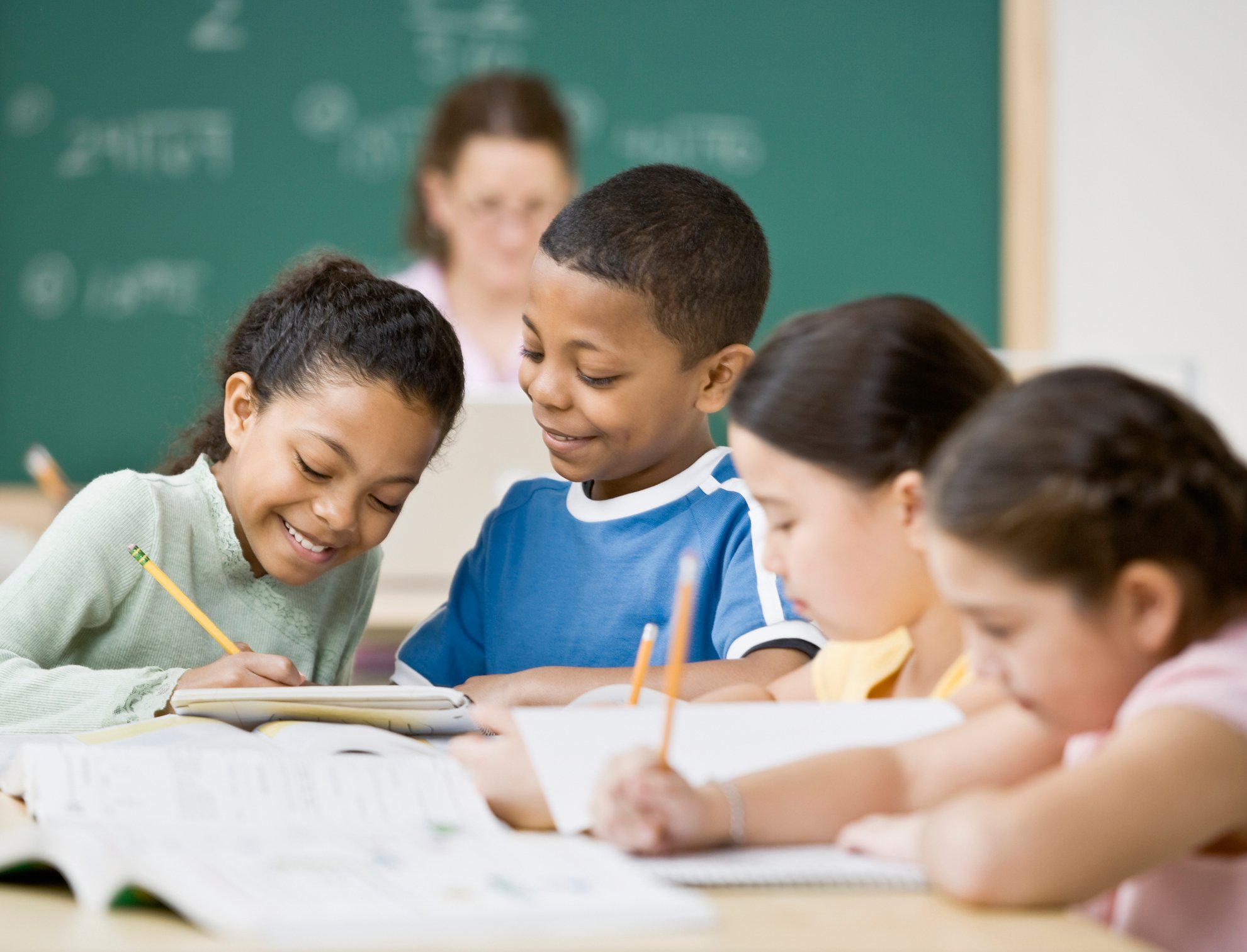Multi-ethnic children writing in classroom