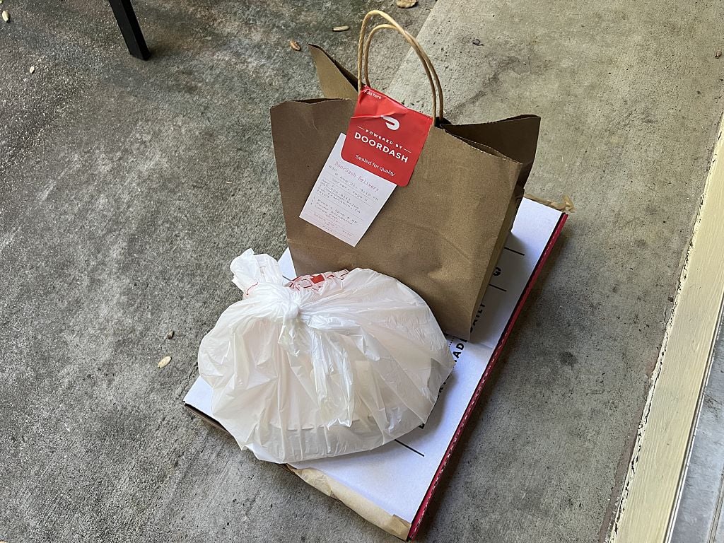 DoorDash food delivery bags and a pizza box left on a concrete doorstep, Reliez Valley, California, United States, August 21, 2026.
