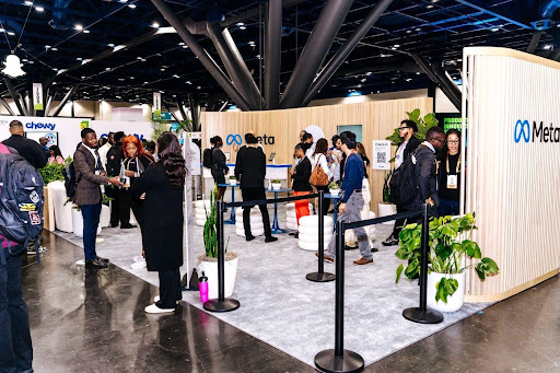 Attendees visit the Meta booth on the AfroTech 2025 expo floor.