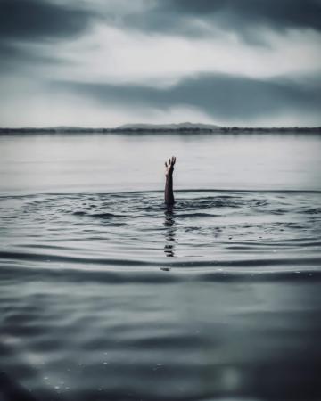 A hand raising out of a body of water