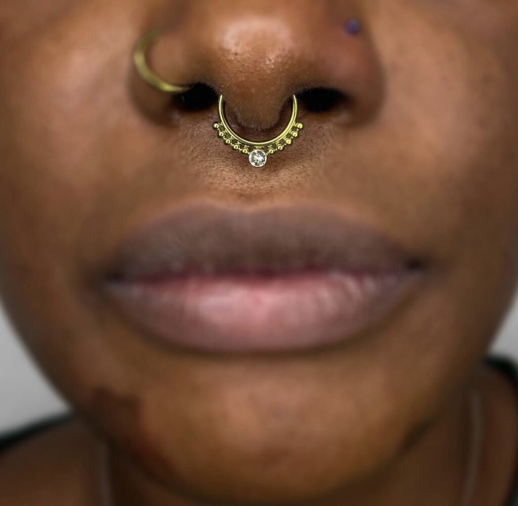 Where septum piercings rank in most painful piercings. pictured: black girl with septum piercing