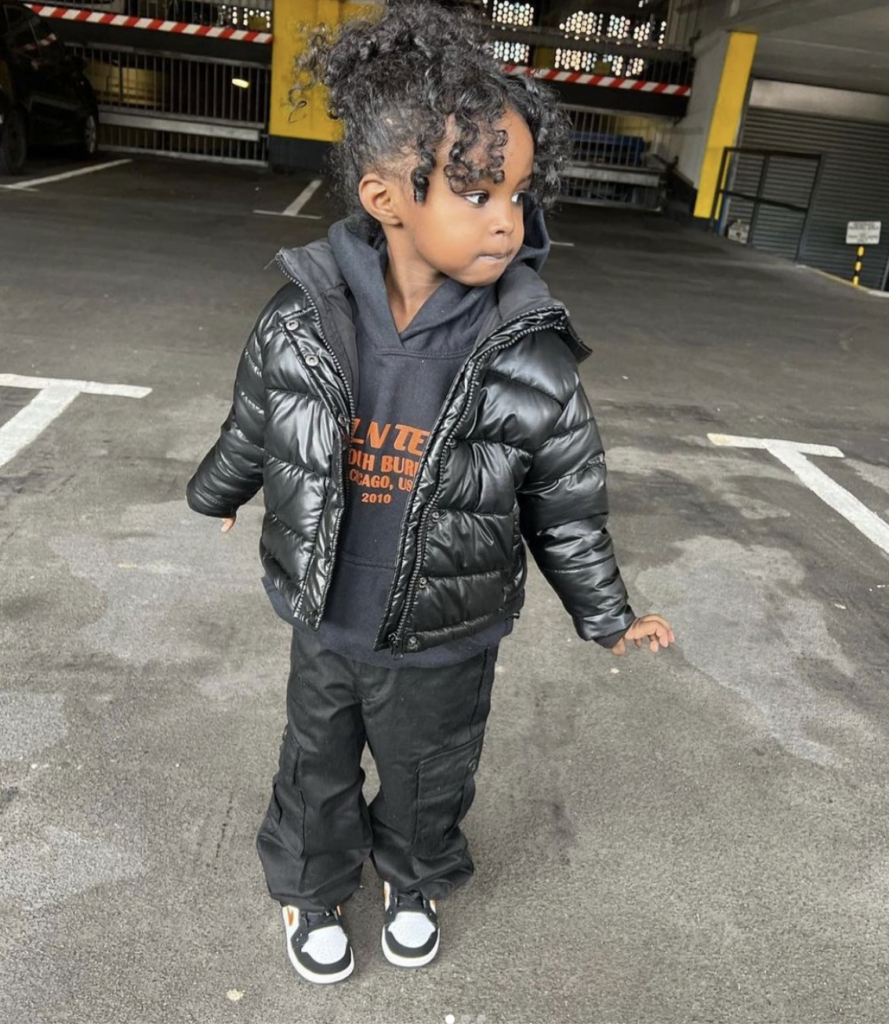 A little girl posing in a hooded jacket