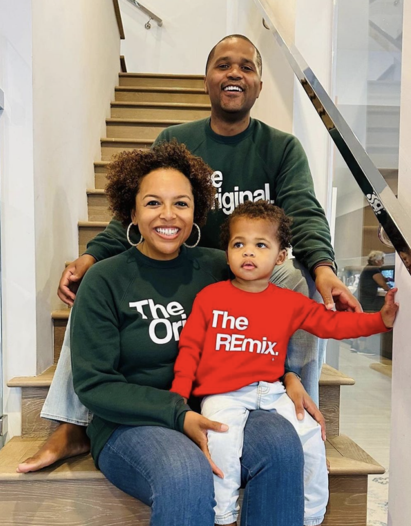 A family of three posing for a photo as they're seated on the stairs