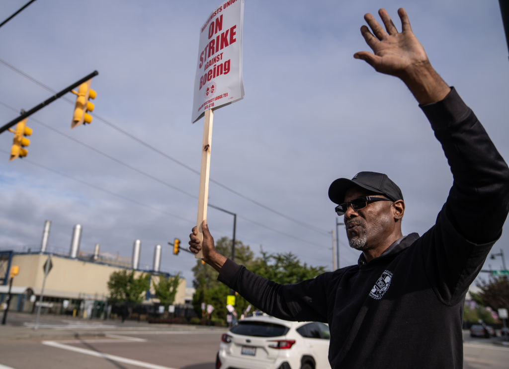 Man holding a sign at Boeing strike | Photo by Stephen Brashear/Getty Images