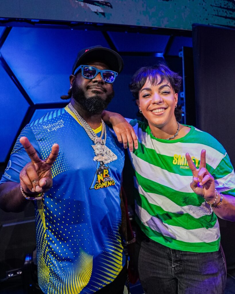 A woman and a man smiling and giving the peace sign