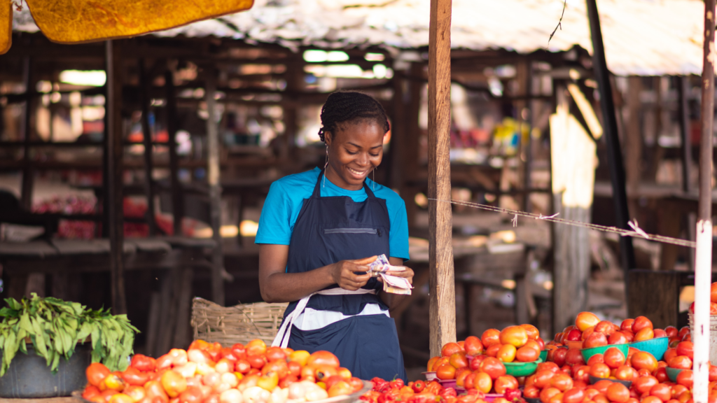 african market woman smiling while counting money