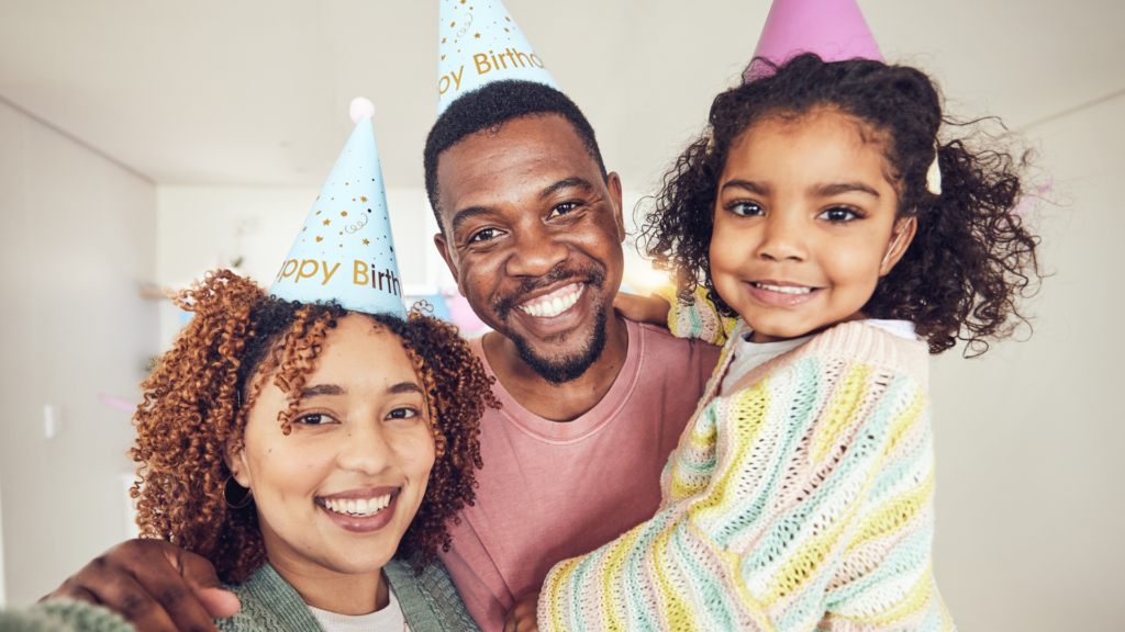 Black family taking selfie for a birthday portrait in home having fun at party celebration