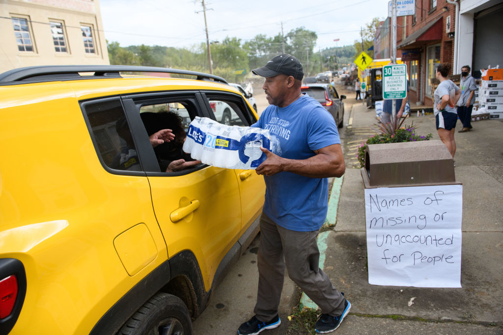 Old Fort Resident Tony J. Daniel, hands out bottled water at the Town Hall on Catawba Avenue in the aftermath of Hurricane Helene on September 30, 2024 in Old Fort, North Carolina.