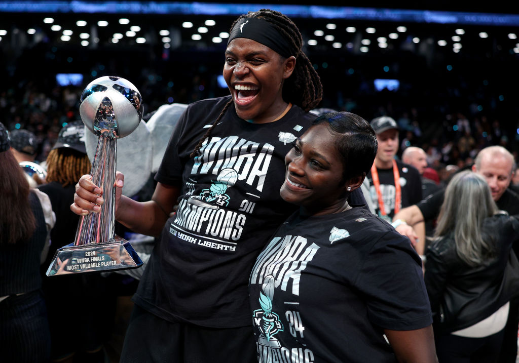 Jonquel Jones #35 of the New York Liberty celebrates with her fiancée
 Nehsa and her MVP trophy after Game Five of the WNBA Finals against the Minnesota Lynx at Barclays Center on October 20, 2024 in the Brooklyn borough of New York City. 