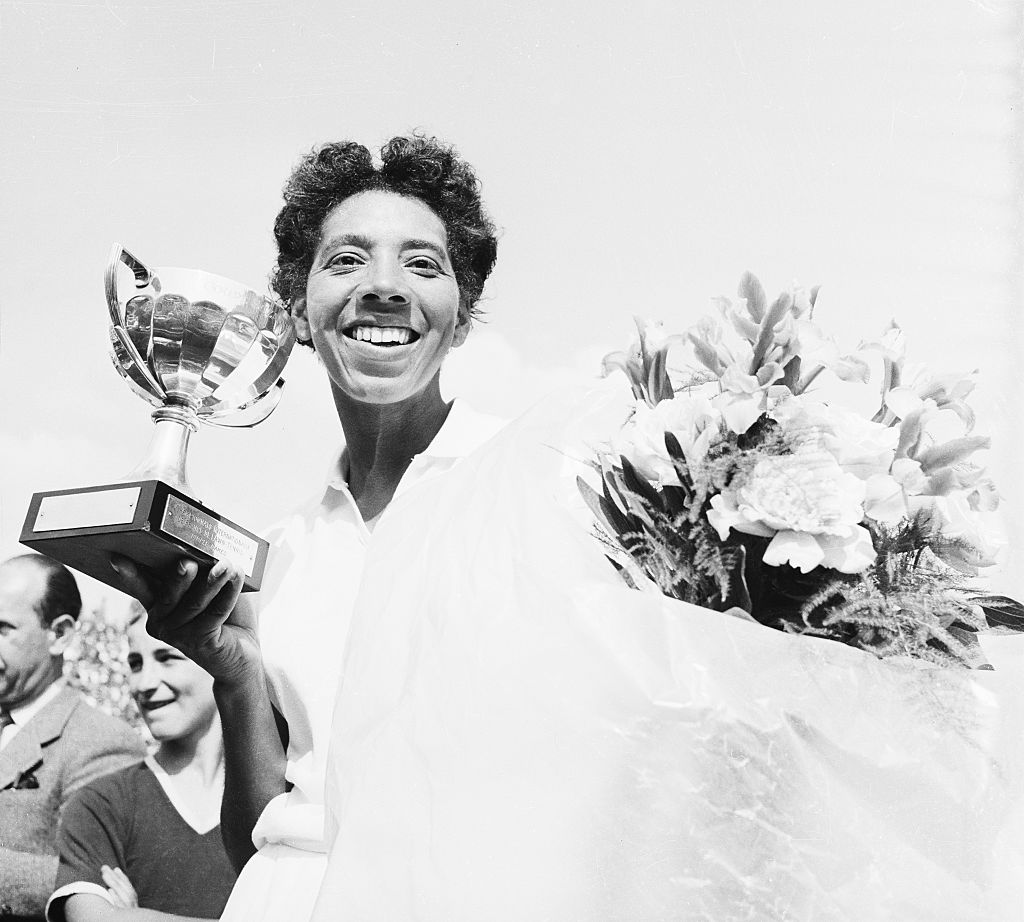 Althea Gibson wins French international tennis championships. Pairs: Nothing like a beautiful Cup to reward a player for the efforts furnished. That's what means American Tennis star Miss player Gibson who kisses the cup she just received for her victory in the finals of France's International Tennis championships.