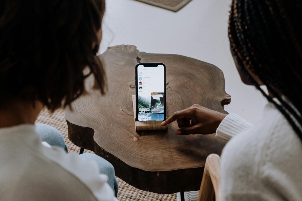 two people looking at a phone screen as one sengages with the screen with the TikTok app icon in view