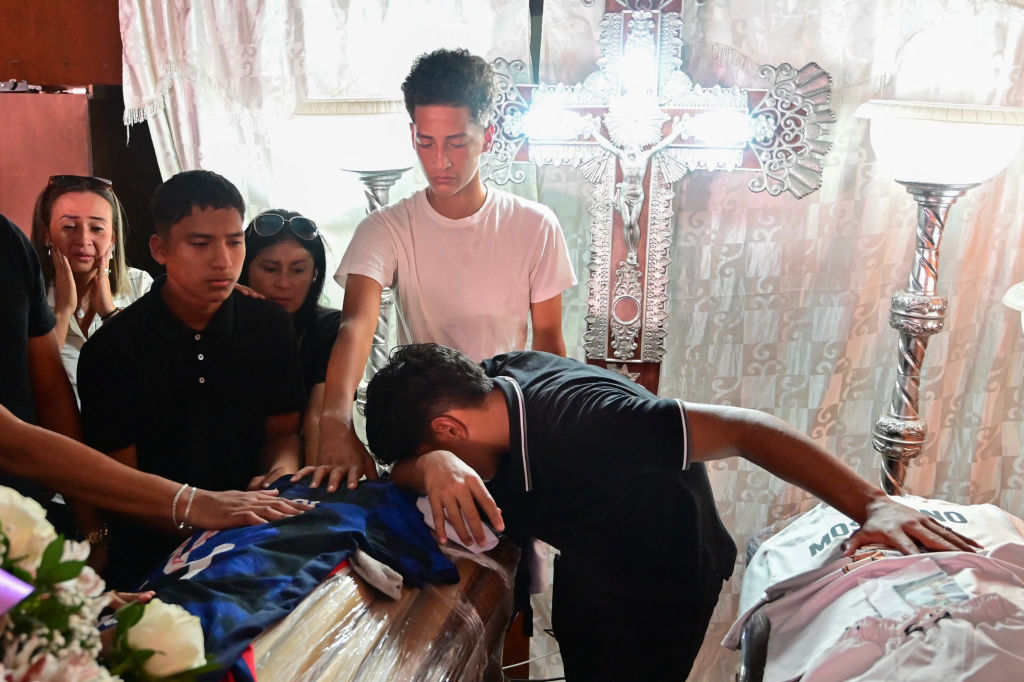 Football teammates of Ismael Arroyo, 15, mourn around his coffin during his wake and that of his brother Josue, 14, two of the four minors who had been missing for three weeks since disappearing during a military operation while playing football, in Guayaquil, Ecuador, on January 1, 2025.