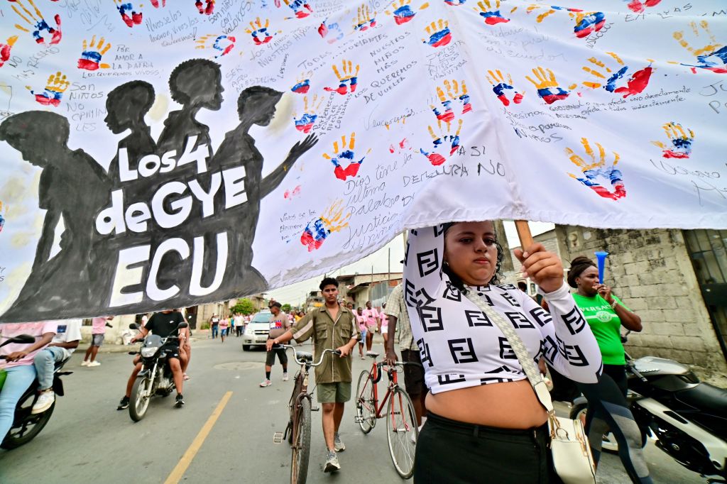 A woman holding an image depicting the four Ecuadorian teenagers apprehended by soldiers and found dead near a military base, attends a march one month after their apprehension in Guayaquil, Ecuador on January 8, 2025.