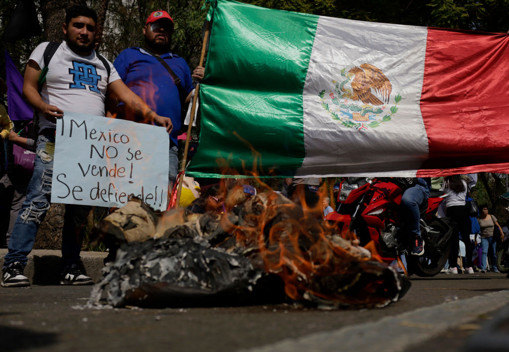 Mexicans and migrants protest while setting fire to a pinata outside the US Embassy in Mexico City, Mexico, on January 20, 2025, against the inauguration of Donald Trump as president of the United States