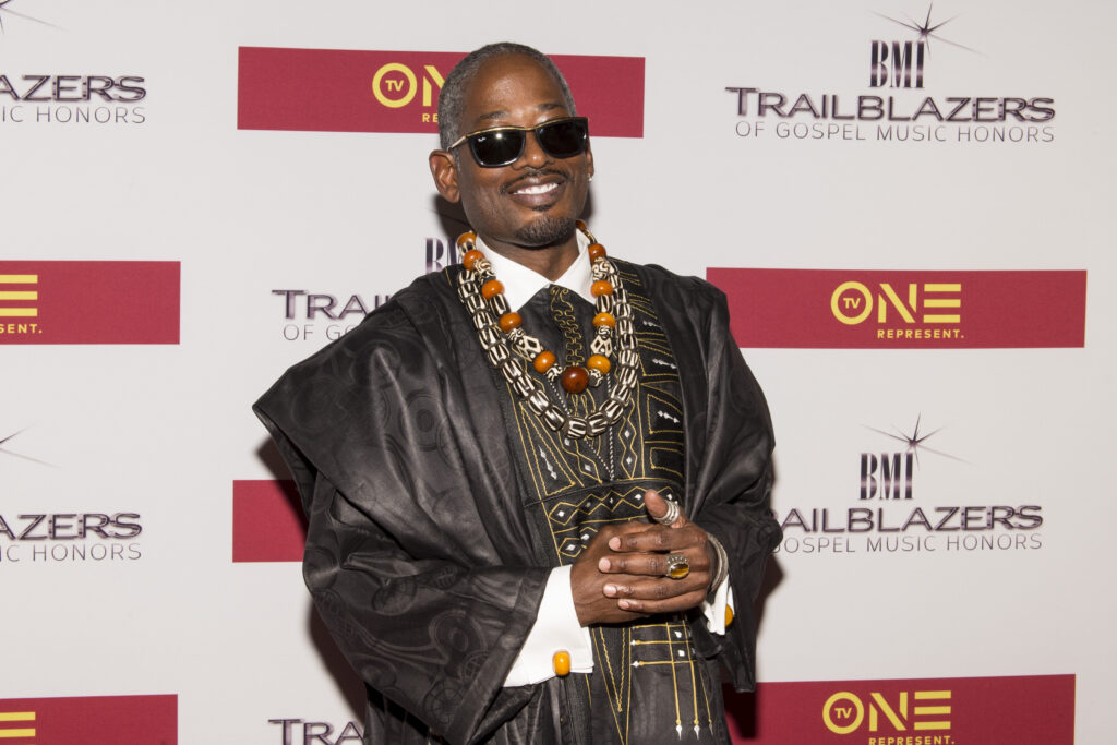 TC Carson dressed in black and gold attire with African-style prints on his jacket during his attendance at the BMI Trailblazers of Gospel Honors at Rialto Center for the Arts on January 14, 2017 in Atlanta, Georgia.