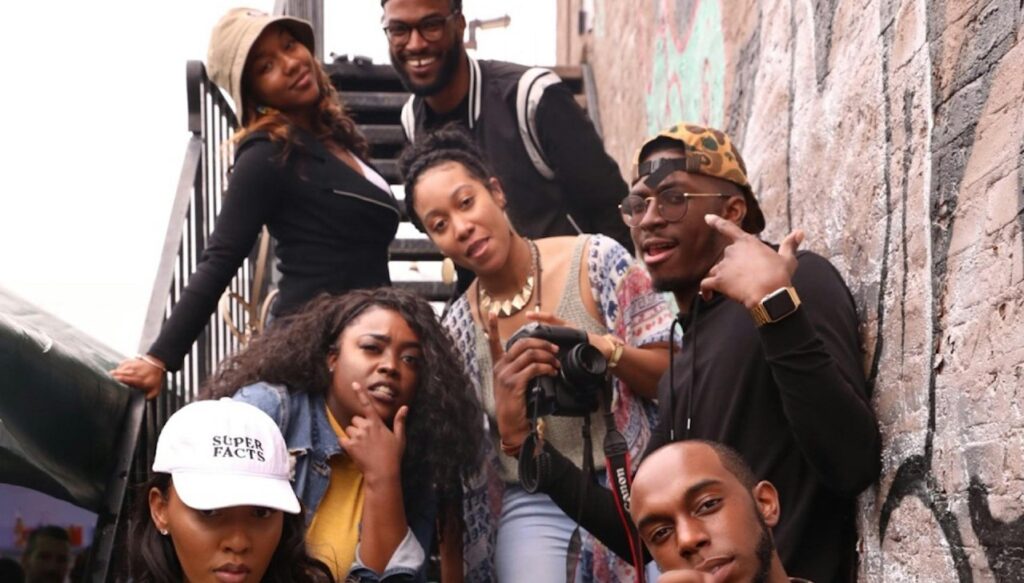 Group of 20-something friends posing for a photo on building steps