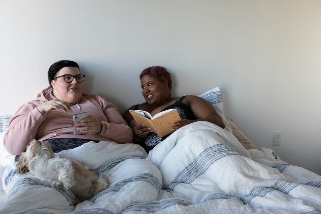 Cozymaxxing pictured: couple relaxing in bed