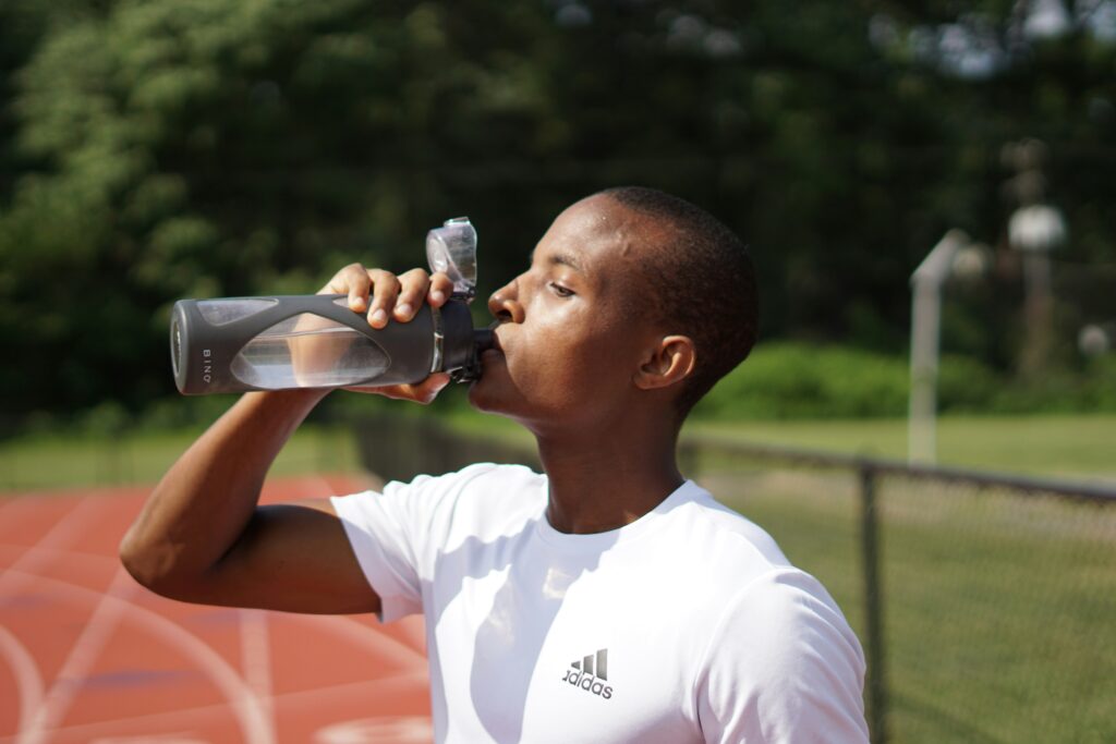 how to cure a sinus infection naturally pictured: man drinking water on running track